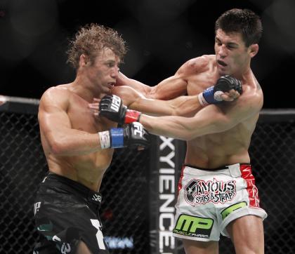 Urijah Faber, left, trades punches with Dominick Cruz during the first round of their second bout in 2011. (AP)