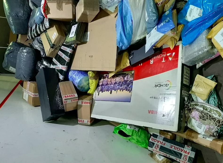 A television can be seen surrounded by piled-up boxes marked fragile (SWNS)