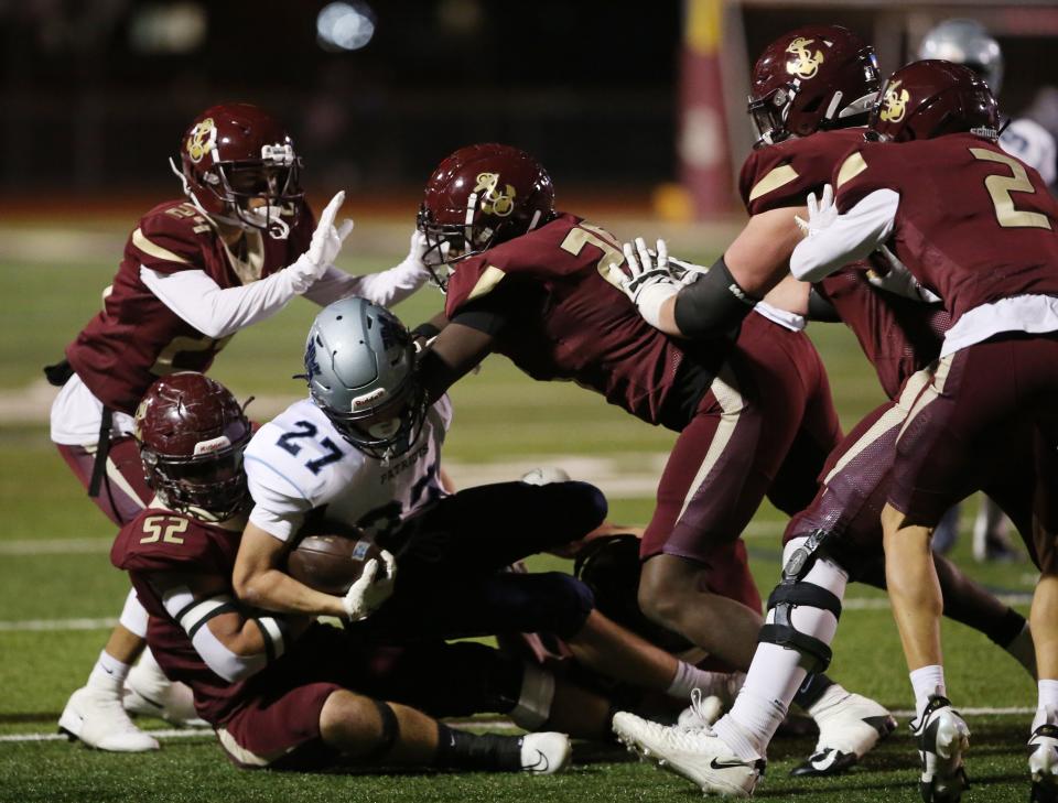Arlington's, frm left, Jason Finn and Nick DeGuisto tackle John Jay's Liam Beale during Friday's Section 1 Class AA semifinal on November 3, 2023.