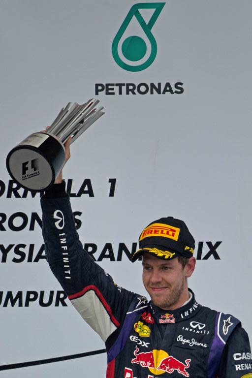 Sebastian Vettel lifts up the third-place trophy at the Malaysian Grand Prix in Sepang on March 30, 2014