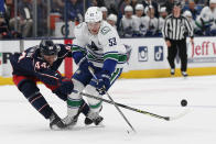 Columbus Blue Jackets' Vladislav Gavrikov, left, knocks the puck away from Vancouver Canucks' Bo Horvat during the first period of an NHL hockey game Friday, Nov. 26, 2021, in Columbus, Ohio. (AP Photo/Jay LaPrete)