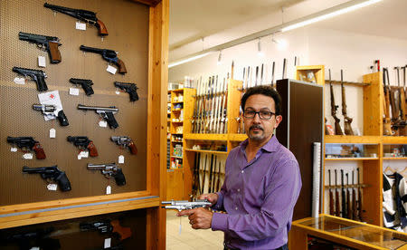 Daniel Wyss, president of the Swiss weapons dealers association, holds a Beretta gun in his Wyss Waffen gun shop in the town of Burgdorf, Switzerland August 10, 2016. REUTERS/Arnd Wiegmann