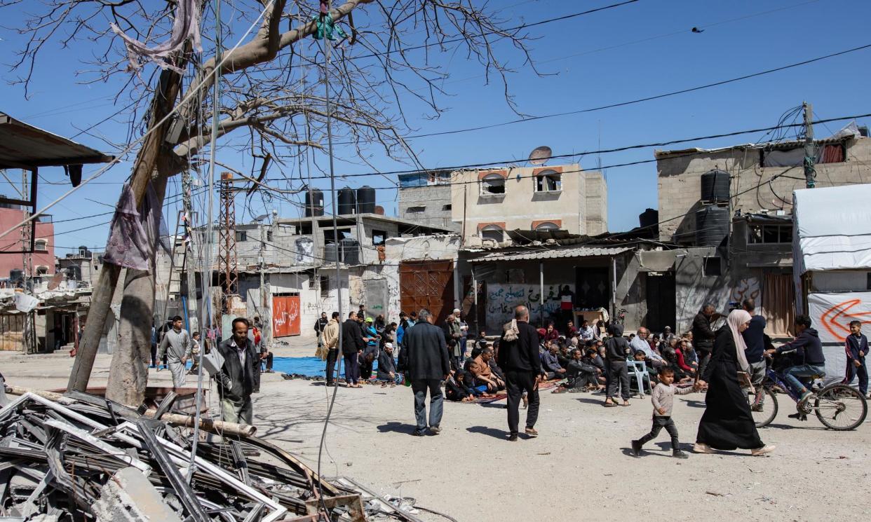 <span>Palestinians arrive to perform the first Friday prayer during Ramadan next to the ruins of a mosque in Rafah.</span><span>Photograph: Haitham Imad/EPA</span>