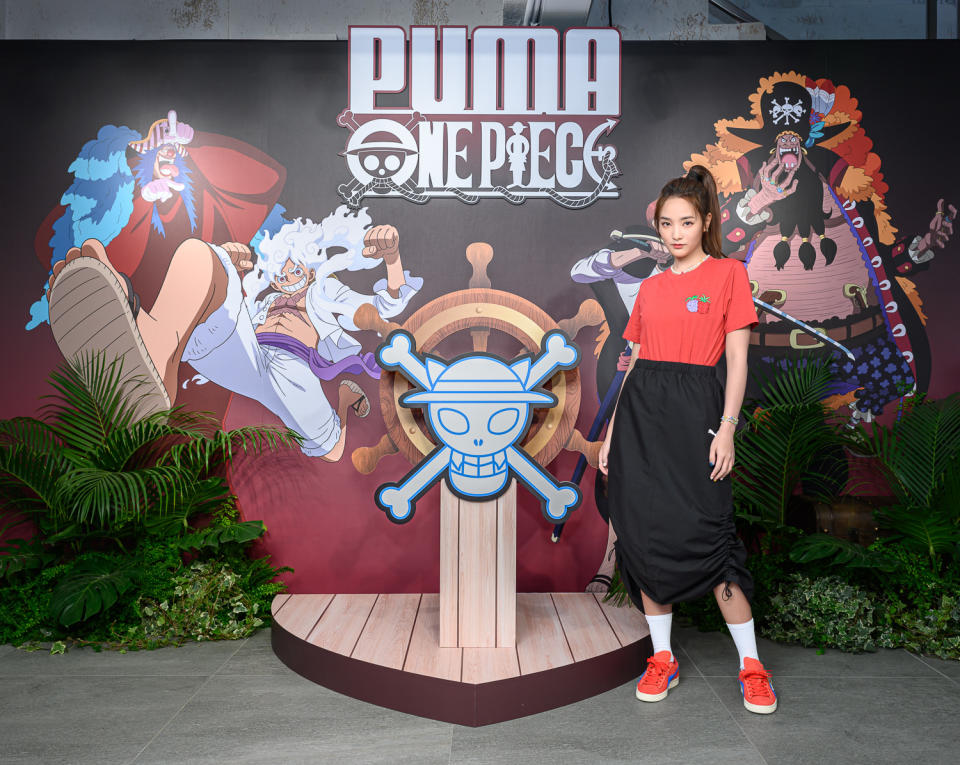 王淨穿上印有新四皇戰鬥圖樣及惡魔果實圖樣的紅色 PUMA x ONE PIECE短T，及紅色 SUEDE ONE PIECE 鞋款！圖片來源:PUMA