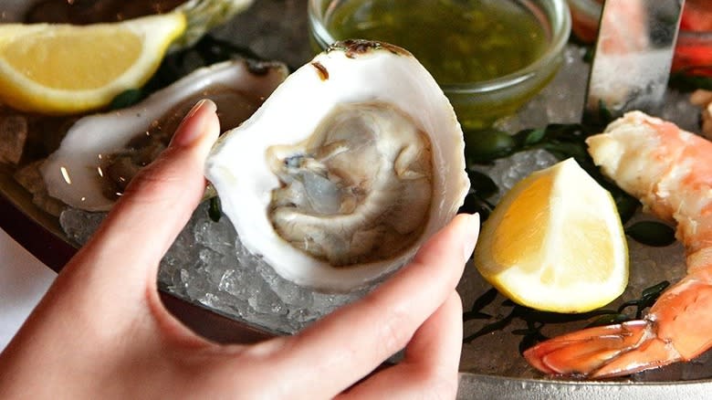 Hand holding raw oyster shell