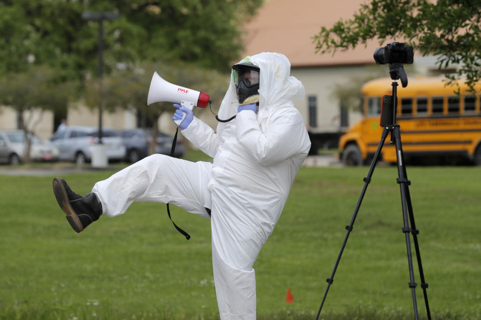 Lance Knippers protests outside as congregants arrive for services at the Life Tabernacle Church in Central, La., Sunday, March 29, 2020. Pastor Tony Spell has defied a shelter-in-place order by Louisiana Gov. John Bel Edwards, due to the new coronavirus pandemic, and continues to hold church services with hundreds of congregants. (AP Photo/Gerald Herbert)