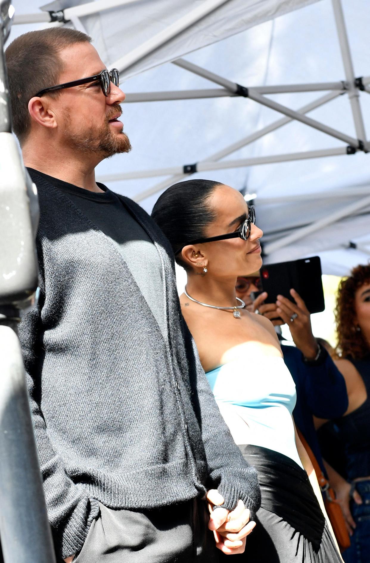 Kravitz, right, and Tatum hold hands as they look on during the event.