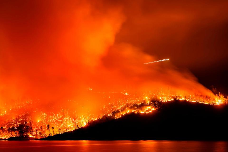 PHOTO: A helicopter flies over the Thompson Fire as it burns above Lake Oroville in Oroville, Calif., Tuesday, July 2, 2024. (Noah Berger/AP)