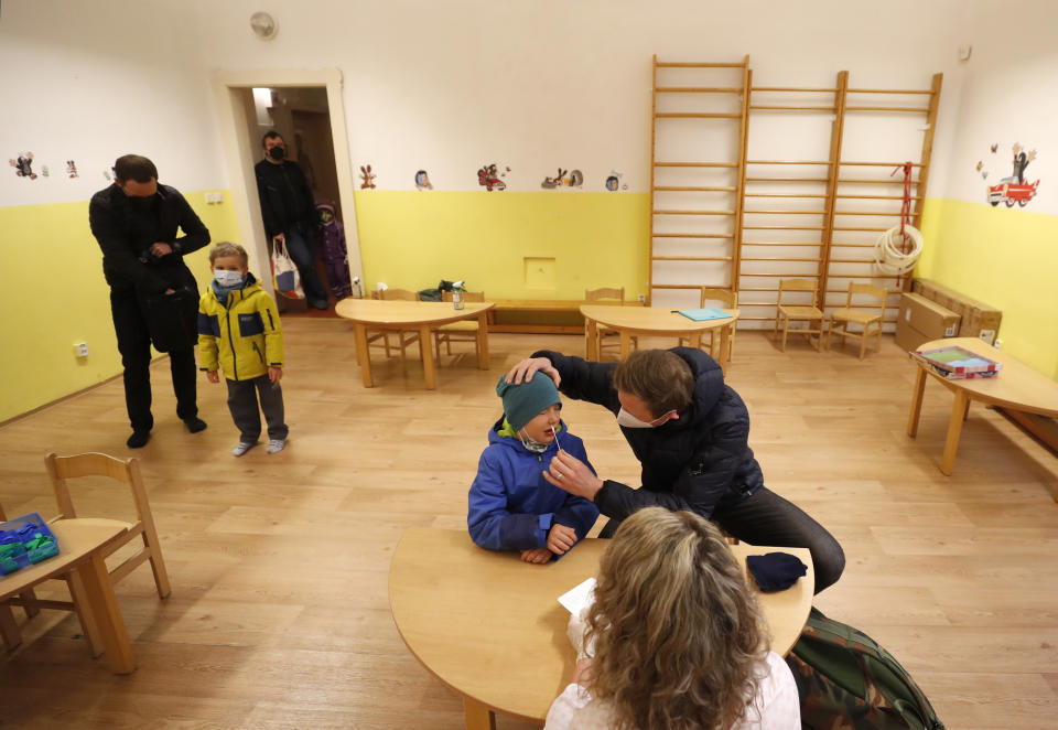 A young boy undergoes rapid COVID-19 test before entering his class at a kindergarden in Prague, Czech Republic, Monday, April 12, 2021. The Czech government has agreed to start easing the tight lockdown in one of the hardest-hit European countries and has given a green light for at least some children to return to schools. (AP Photo/Petr David Josek)