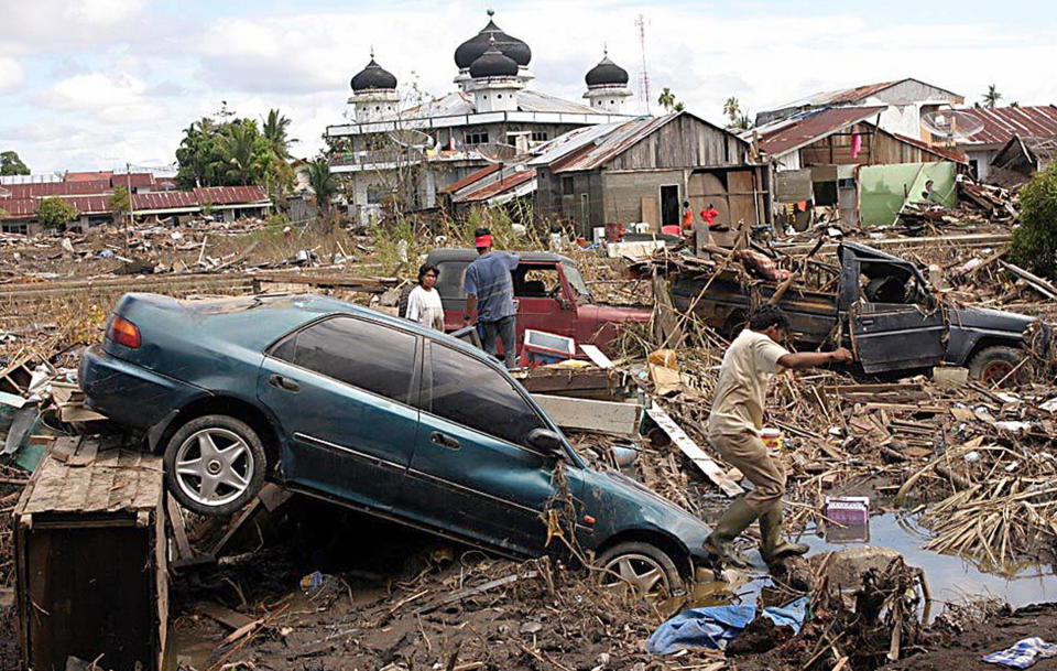 Residents from Meulaboh town, west of Aceh, search through debris on Dec. 31, 2004.  / Credit: AGUS/AFP via Getty Images