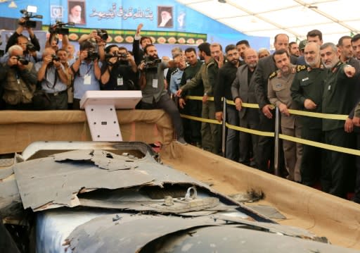 Iranian Revolutionary Guards commander Major General Hossein Salami (2-R) and General Amir Ali Hajizadeh (R), head of the aerospace division, earlier this week look at debris from what Tehran has presented as a downed US drone