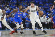 Dallas Mavericks guard Luka Doncic, right, works the floor against Oklahoma City Thunder guard Cason Wallace during the first half in Game 2 of an NBA basketball second-round playoff series, Thursday, May 9, 2024, in Oklahoma City. (AP Photo/Kyle Phillips)