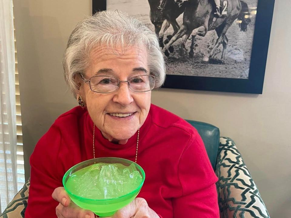 Dora Martin from Arcadia senior living smiles and holds a cup.