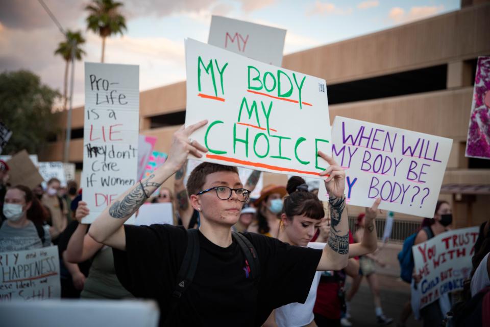 Zoe Wheat marches with abortion rights activists holding a sign that reads, "My body My choice," during an abortion rights protest near the Arizona Capitol in Phoenix on July 1, 2022.