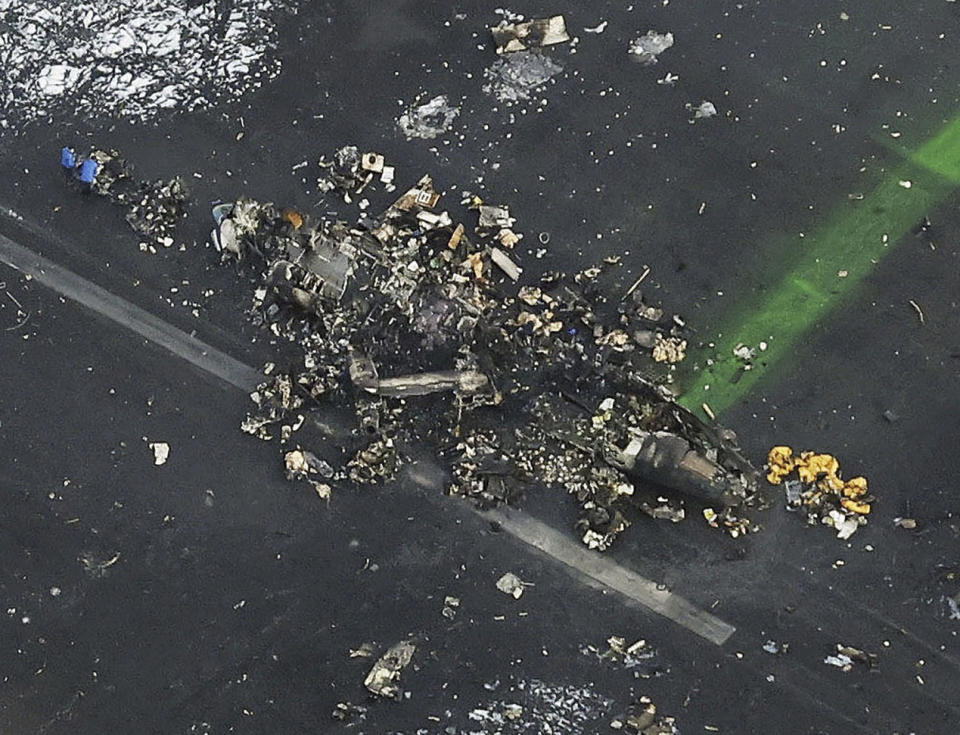 FILE - This aerial photo shows the burn-out Japanese coast guard aircraft at Haneda airport in Tokyo, on Jan. 3, 2024. The 379 passengers of Japan Airlines Flight JAL-516 didn't expect their plane to burst into flames just as it was about to touchdown at Tokyo’s Haneda airport Tuesday evening. A smaller coast guard Bombardier Dash-8 aircraft, preparing to take off to deliver urgent aid to quake-hit central Japan, was using the same runway when the two collided. The Associated Press collected accounts from witnesses, officials and transcripts of the traffic controls communication. (Kyodo News via AP, File)