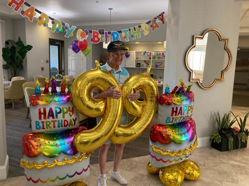 Richard Mirelles surrounded by balloons at his 99th birthday.