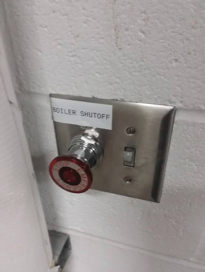 A boiler shutoff switch with a large, red emergency stop button