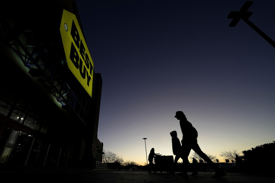 FILE - Shoppers are silhouetted against the sky as they arrives for a sale at a Best Buy store Friday, Nov. 25, 2022, in Overland Park, Kan. On Friday, the Commerce Department issues its February report on consumer spending. (AP Photo/Charlie Riedel, File)