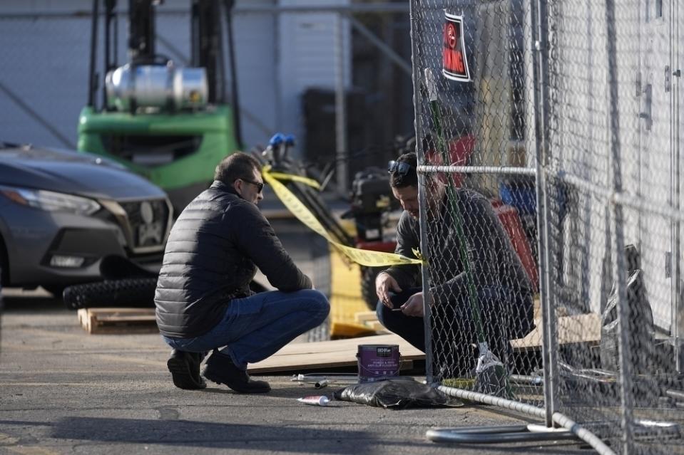 Dos personas trabajan en un refugio para migrantes --una carpa en el estacionamiento de una vieja tienda CVS-- el 1 de febrero de 2024, en el barrio Little Village de Chicago. (AP Foto/Erin Hooley)