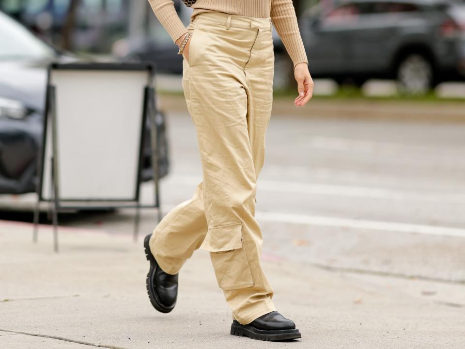 Model wearing cargo pants and a tan shirt.