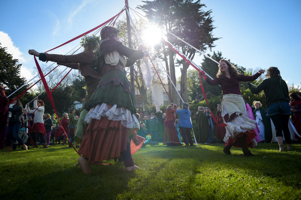 People take part in the traditional maypole dance at the Chalice Well, Glastonbury, where Beltane festivities are taking place on May Day.