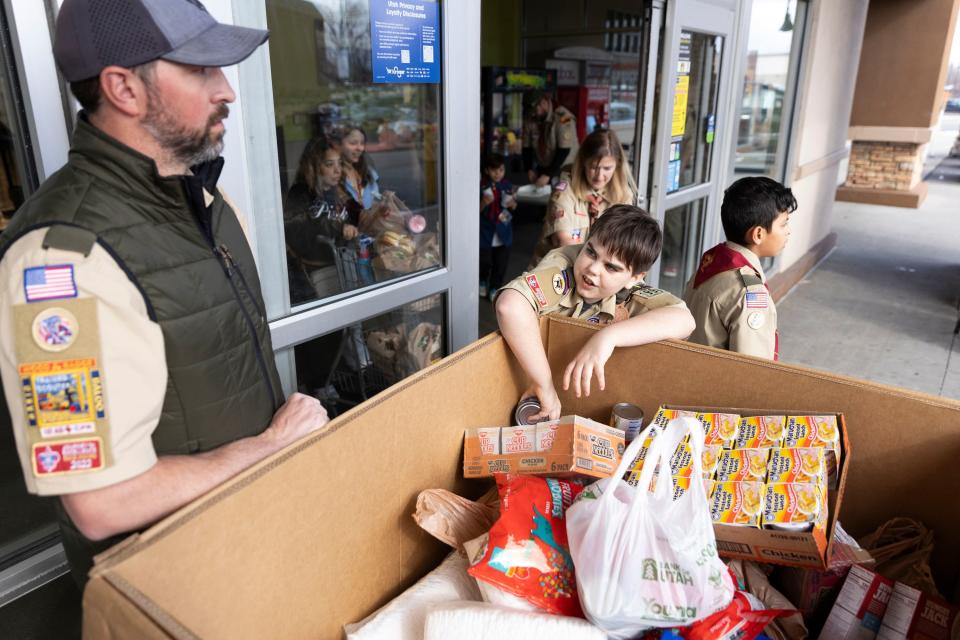 Christian McDonald of Troop 1996 puts donated food into a box during a food drive at Smith’s Grocery in West Valley City on Saturday, Feb. 10, 2024. | Marielle Scott, Deseret News