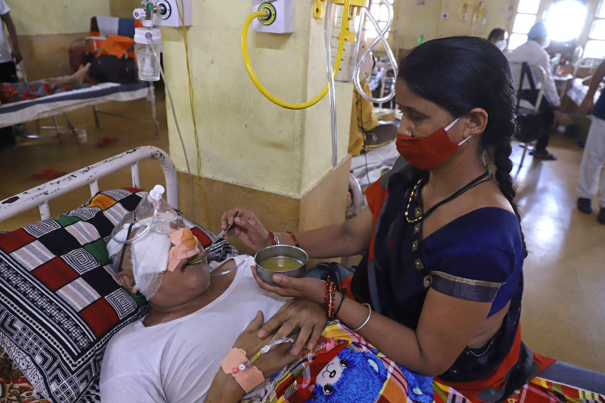 Image: An attendant sits next to a patient who recovered from the Covid-19 coronavirus and is now infected with the deadly fungal infection in Jabalpur on Friday. (Uma Shankar Mishra / AFP - Getty Images)