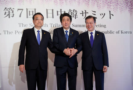 Chinese Premier Li Keqiang, Japanese Prime Minister Shinzo Abe and South Korean President Moon Jae-in pose for photographers prior to their summit in Tokyo, Wednesday, May 9, 2018. Eugene Hoshiko/Pool via Reuters
