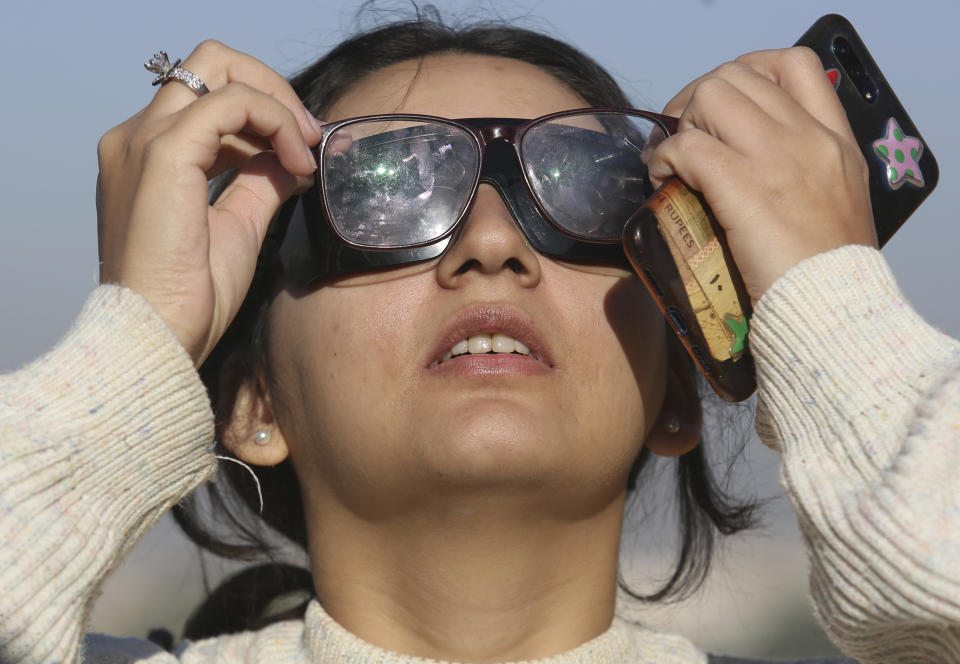 A student of Karachi University views the solar eclipse seen from Karachi, Pakistan, Thursday, Dec. 26, 2019. The last solar eclipse of 2019 was witnessed in Pakistan along with several other countries. (AP Photo/Fareed Khan)