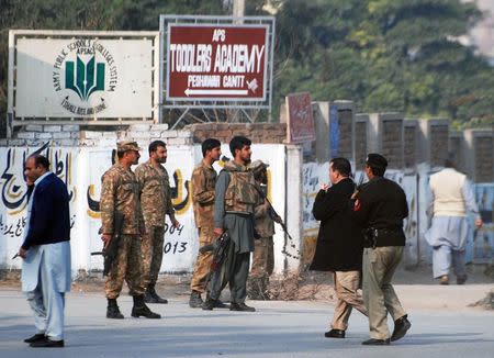 Pakistani security forces takes up a positions on a road leading to the Army Public School that is under attack by Taliban gunmen in Peshawar, December 16, 2014. REUTERS/Khuram Parvez