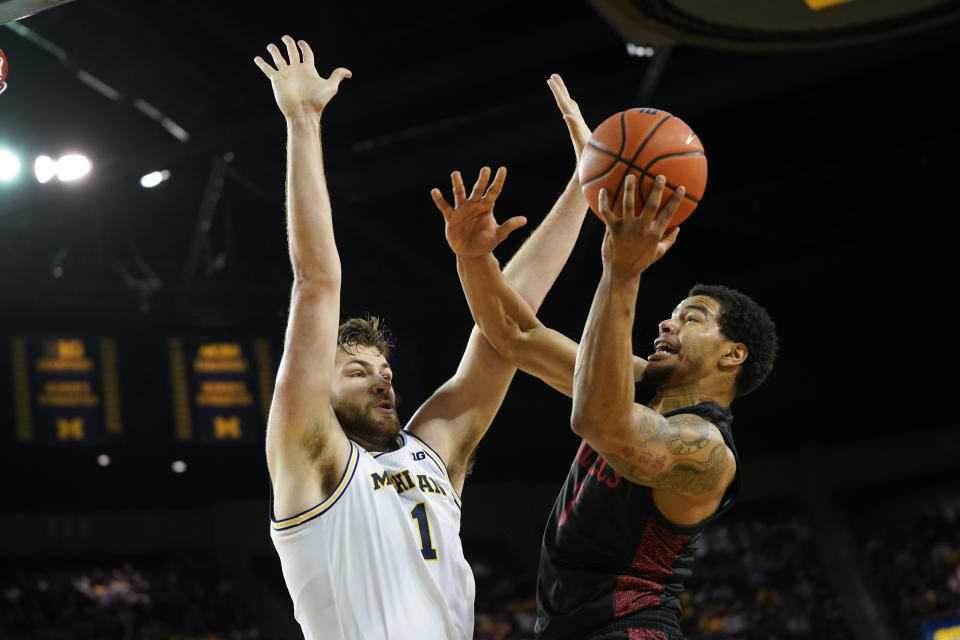 Michigan guard Zeb Jackson (3) drives on Michigan center Hunter Dickinson (1) in the first half of an NCAA college basketball game in Ann Arbor, Mich., Saturday, Dec. 4, 2021. (AP Photo/Paul Sancya)