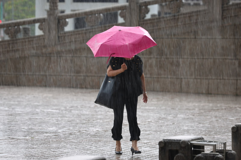 午後對流旺盛　10縣市大雨特報 對流雲系發展旺盛，易有短延時強降雨，中央氣象署 21日下午發布10縣市大雨特報。圖為台北市中正區下 午下起大雨，民眾撐傘遮擋雨勢。 中央社記者王騰毅攝  113年6月21日 