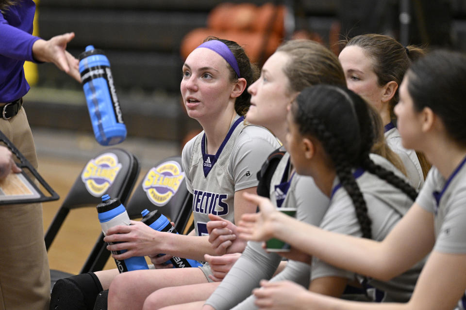 University Health Sciences and Pharmacy guard Grace Beyer, left, sits with her teammates during an NAIA college basketball game against Cottey College Thursday, Feb. 22, 2024, in St. Louis. Byer scored 40 points for University Health Sciences Pharmacy in a close loss to Cottey College. (AP Photo/Jeff Le)