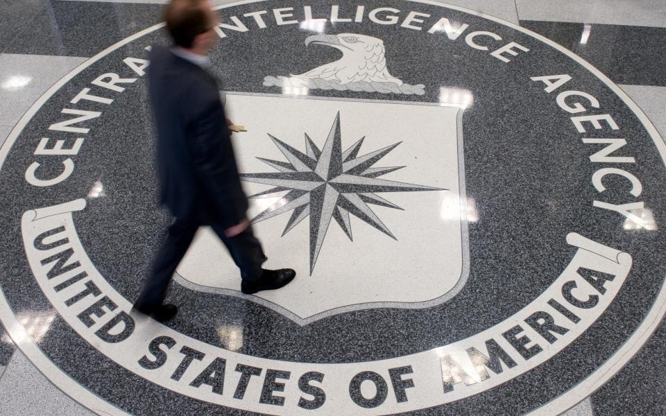 A man crosses the Central Intelligence Agency (CIA) logo in the lobby of CIA Headquarters in Langley, Virginia - SAUL LOEB/AFP/Getty Images