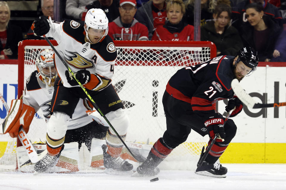 Carolina Hurricanes' Derek Stepan (21) has the puck taken away by Anaheim Ducks' Cam Fowler (4) in front of Ducks goaltender John Gibson (36) during the first period of an NHL hockey game in Raleigh, N.C., Saturday, Feb. 25, 2023. (AP Photo/Karl B DeBlaker)