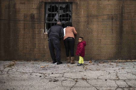 A family looks through the destroyed windows of the Flood Christian Church, which was set a flame during recent unrest in Ferguson, Missouri November 30, 2014. REUTERS/Adrees Latif