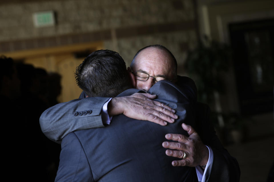 In this Friday, Jan. 10, 2014 photo, Mikey Cortez's father, Paul, facing camera, is comforted by a well-wisher at a funeral service for his son, in Murietta, Calif. As his 7-year-old son Mikey lay in a hospital bed on life support, the victim of a drunk driver who had smashed into the car he was riding in, Paul Cortez took the boy's hand and made a solemn promise to God: If his son survived, no matter in what condition, he and his family would always be there for him. Although he would never emerge from the persistent vegetative state his father had found him in that night, Mikey’s family was not only there for him but also gave him a full life. A life, as it turned out, not all that different from anybody else’s, with cross-country family vacations and visits to Disneyland.(AP Photo/Jae C. Hong)