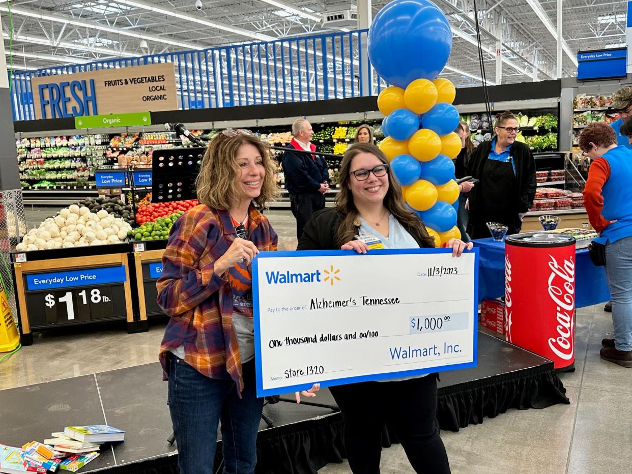 The ceremony included grants to local community organizations. Store manager Jessica Cecil, right, presents a $1,000 check to Alzheimer's Tennessee.