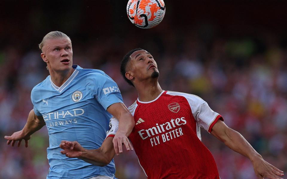 William Saliba battles for the ball with Erling Haaland