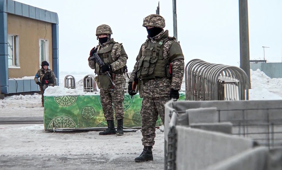 In this image taken from footage provided by the RU-RTR Russian television, Kazakhstan's soldiers guard a check point in Kazakhstan, Friday, Jan. 7, 2022. The President of Kazakhstan said Friday he authorized law enforcement to open fire on "terrorists" and shoot to kill, a move that comes after days of extremely violent protests in the former Soviet nation. The alliance, the Collective Security Treaty Organization, includes the former Soviet republics of Russia, Kazakhstan, Belarus, Armenia, Tajikistan and Kyrgyzstan and has started deploying troops to Kazakhstan for a peacekeeping mission. (RU-RTR Russian Television via AP)