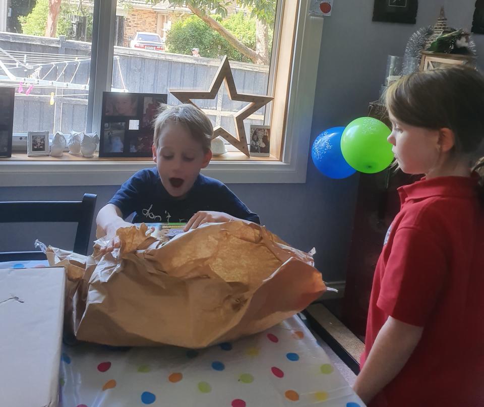 Nash Zabielski, pictured opening a present, was very excited to receive the note for his birthday and it is still hanging on the family's fridge.