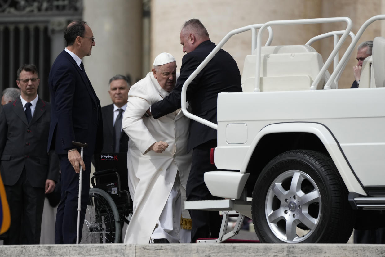Pope Francis helped to get on his car at the end of weekly general audience in St. Peter's Square, at the Vatican, Wednesday, March 29, 2023. Pope Francis went to a Rome hospital on Wednesday for some previously scheduled tests, slipping out of the Vatican after his general audience and before the busy start of Holy Week this Sunday. (AP Photo/Alessandra Tarantino)