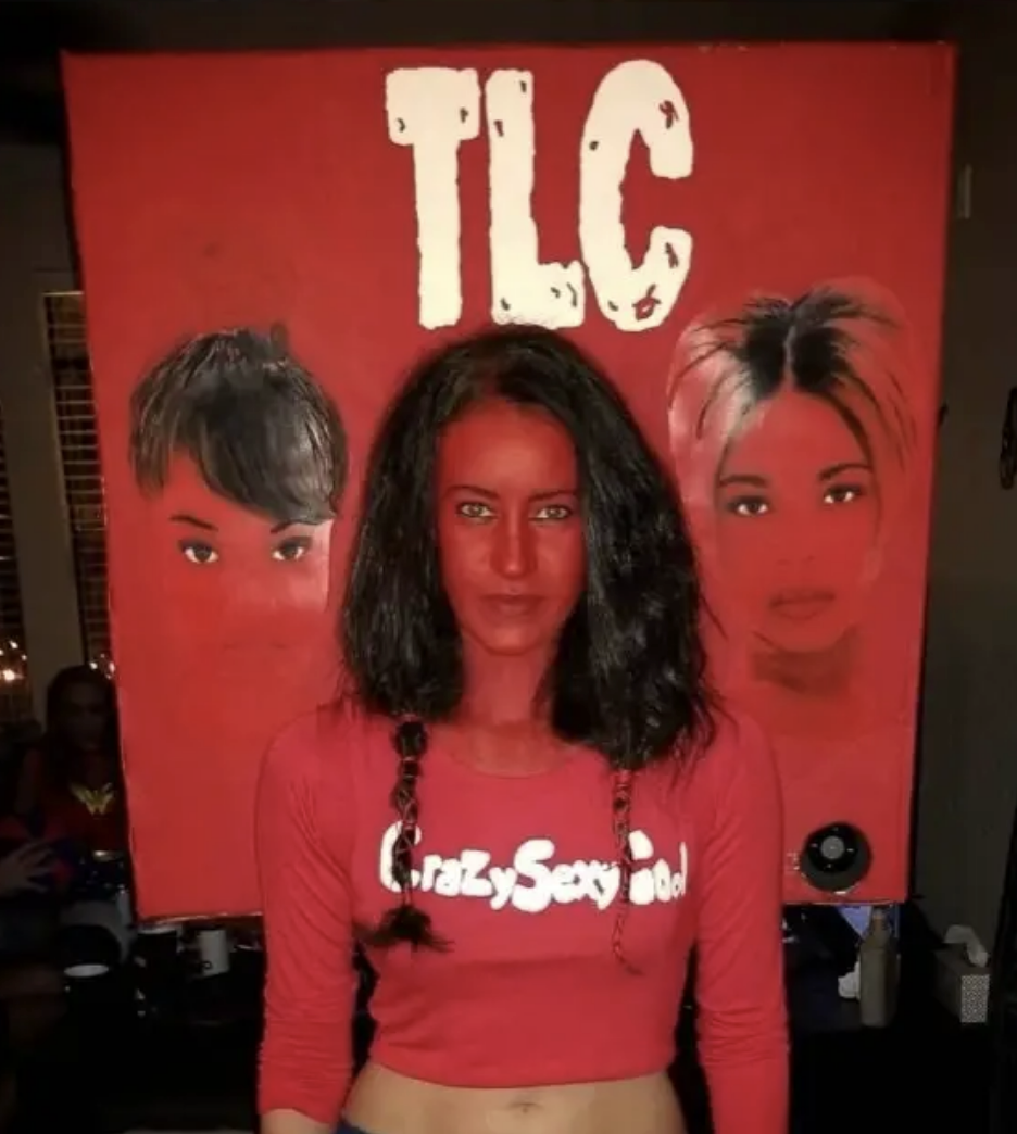 A woman in red, dressed as the CrazySexyCool album cover