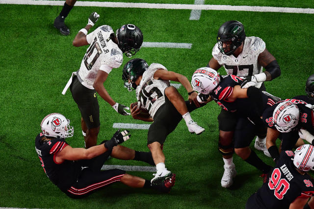 December 3, 2021; Las Vegas, NV, USA; Oregon Ducks running back Travis Dye (26) is brought down by Utah Utes defensive end Van Fillinger (7) and linebacker Karene Reid (32) during the second half in the 2021 Pac-12 Championship Game at Allegiant Stadium. Mandatory Credit: Gary A. Vasquez-USA TODAY Sports