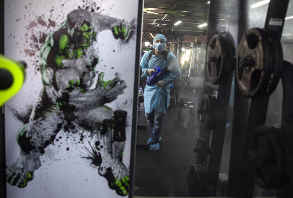 A Palestinian health worker sprays disinfectant as a precaution against the coronavirus in a gymnasium in Gaza City, Sunday, March 15, 2020. (AP Photo/Khalil Hamra)