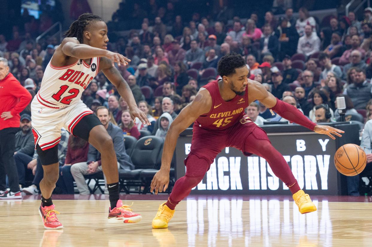 Cleveland Cavaliers' Donovan Mitchell (45) controls the ball as Chicago Bulls' Ayo Dosunmu (12) defends during the first half of an NBA basketball game Wednesday, Feb. 14, 2024, in Cleveland. (AP Photo/Phil Long)