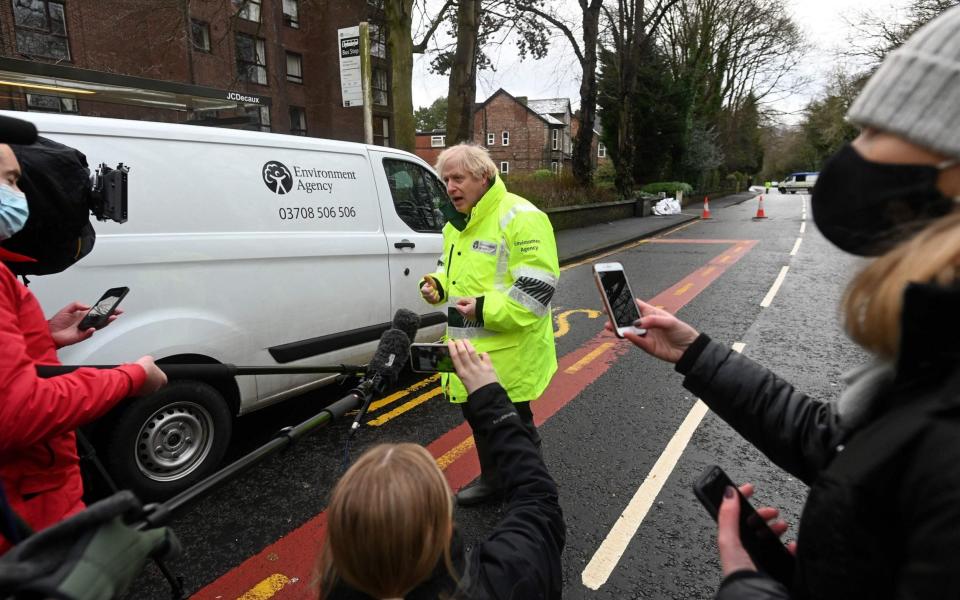 Britain's Prime Minister Boris Johnson talks to members of the media after being shown the Environment Agency's flood defence preparations during his visit to Withington in Manchester - PAUL ELLIS/AFP via Getty Images