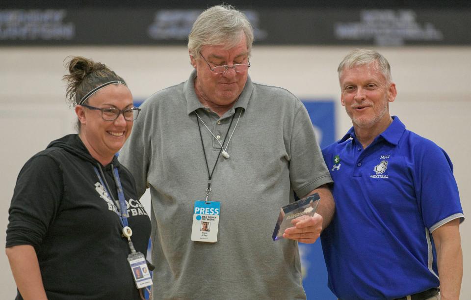 MDCA athletic director Megan Ziegelhofer and basketball coach Steven Hayes present Daily Commercial sports reporter Frank Jolley with an award during a game at Mount Dora Christian Academy in Mount Dora on Jan. 28, 2022.