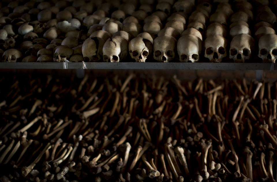 FILE - In this Friday, April 4, 2014 file photo, the skulls and bones of some of those who were slaughtered as they sought refuge inside the church, are laid out on shelves in an underground vault as a memorial to the thousands who were killed in and around the Catholic church during the 1994 genocide in Nyamata, Rwanda. France and Rwanda are hoping to reset ties scarred by a quarter century of recriminations over the 1994 Rwandan genocide when French President Emmanuel Macron visits the central African country. (AP Photo/Ben Curtis, File)