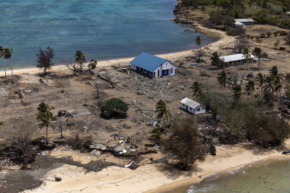 In this photo provided by the Australian Defence Force, debris from damaged building and trees are strewn around on Atata Island in Tonga, on Jan. 28, 2022, following the eruption of an underwater volcano and subsequent tsunami. The international aid Tonga accepted after the disaster has caused the country's first COVID-19 outbreak, and there are worries the isolation that kept Tonga and other Pacific nations virus-free until now will hurt their ability to manage the public health threat.(POIS Christopher Szumlanski/Australian Defence Force via AP)